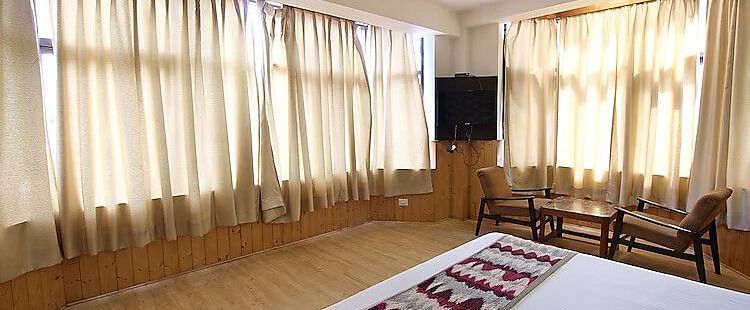 A room at DLS Hotel Devlok, Manali with a double bed and a television attached to a corner