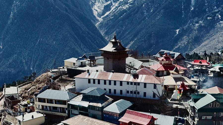 An image of a town settlement with the backdrop of the Himalayan mountains