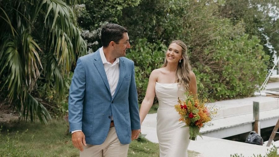 Bride and groom walking hand-in-hand on a pathway flanked by greenery at Casa Morada.