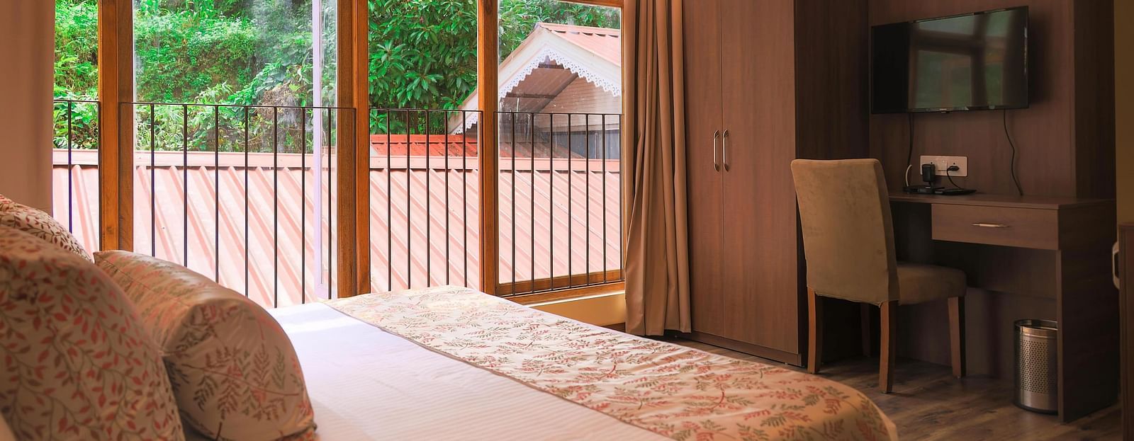 corner view image of the Premier plus room featuring a queen size bed with a wardrobe and a wall mounted television