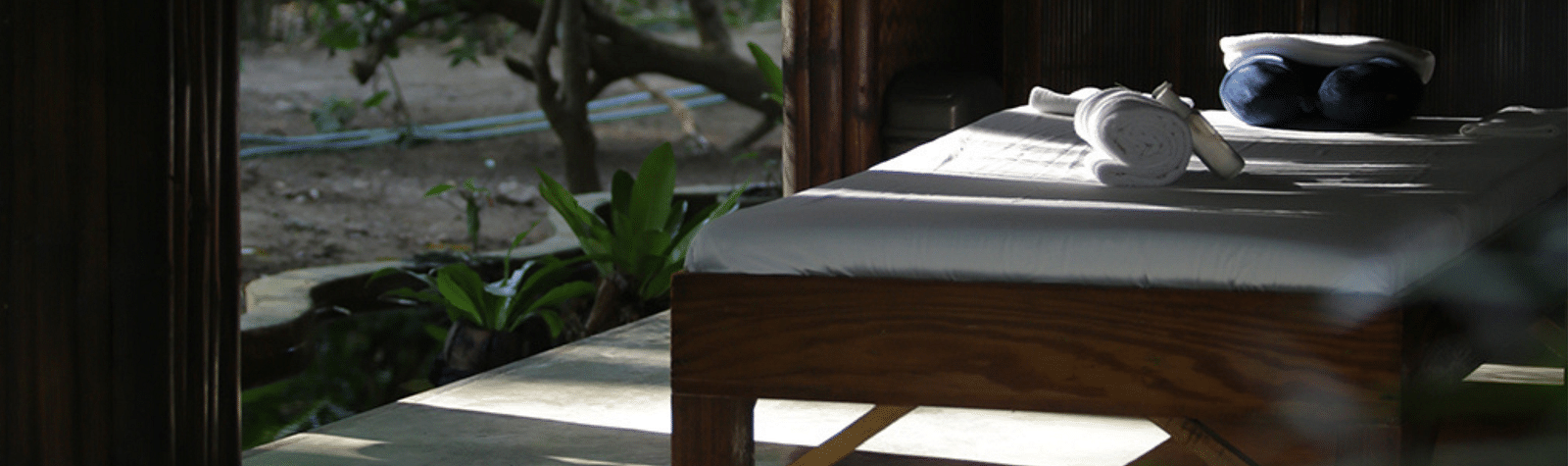 Massage table set outdoors facing the beach under the shade at Flower Island Resort.
