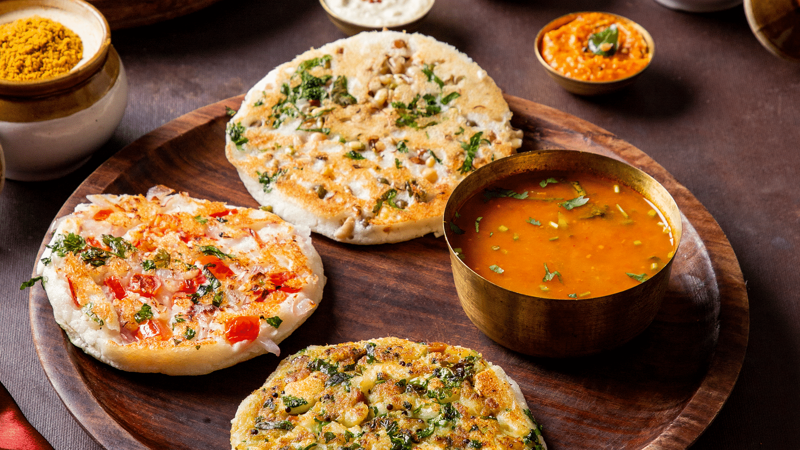 Assorted Indian vegetarian dishes on traditional pottery, vibrant and appetising | Kamats India