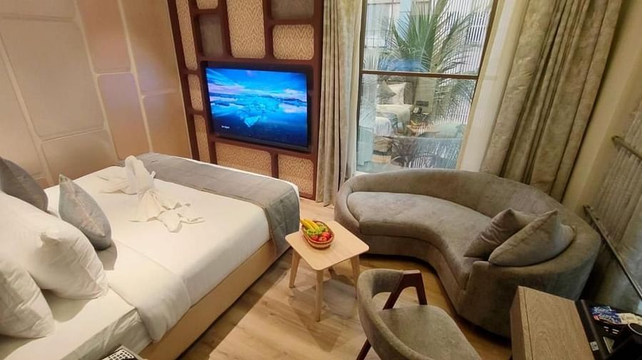 Suit Rooms with a comfy bed and a flat screen TV, a comfortable sofa , table and chair at Maxxvalue Hotel, MIDC