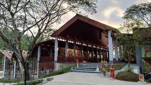 Small figurines leading to the entrance of a tall pillared building - Symphony Samudra Beachside Jungle Resort And Spa, Port Blair