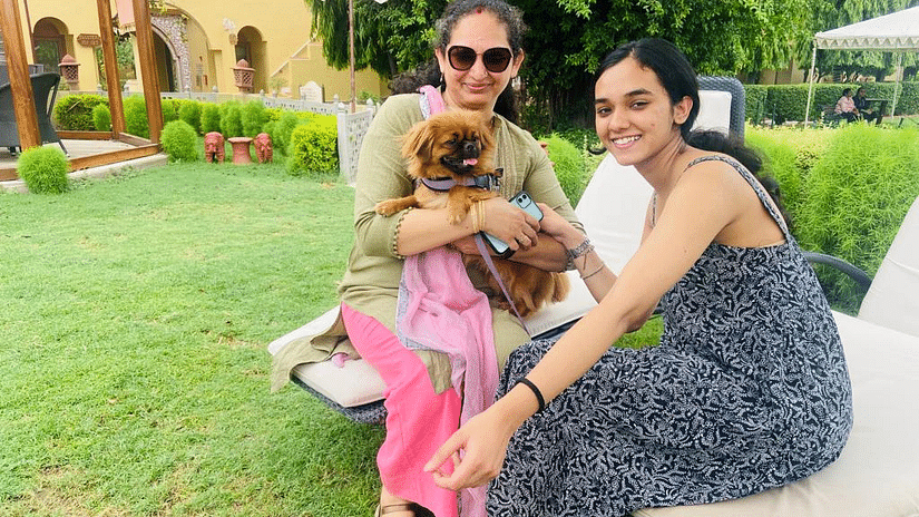 a mother and daughter posing with their pet dog