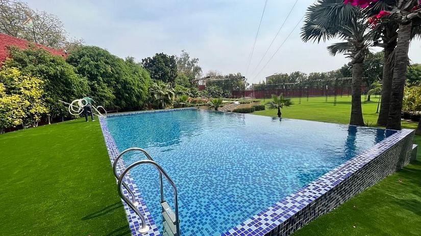 The Lalitha Grand - Swimming pool next to a garden with tree covers on the side
