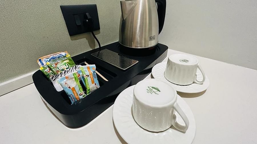 An image displaying a kettle, tea and coffee sachets, along with cups and plates - Five Elements Hotels Goldleaf, Haldwani