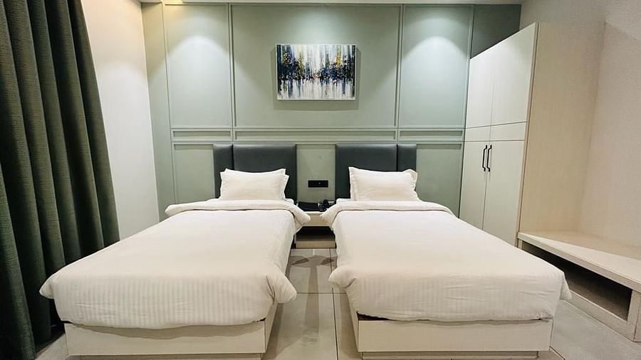 A room offering twin beds, adorned with a wall painting and equipped with a wardrobe - Five Elements Hotels Goldleaf, Haldwani