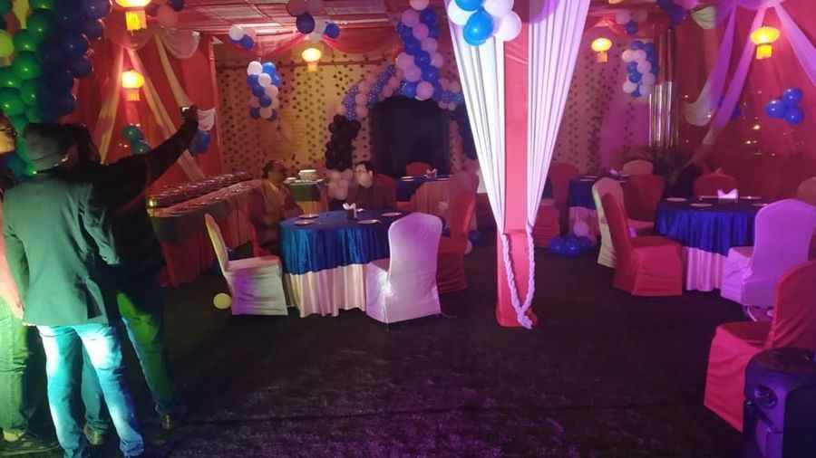 A vibrant party hall with colorful lighting, elegant seating arrangements and festive decorations at one of the popular banquet halls in Varanasi - Hotel Uday Palace 