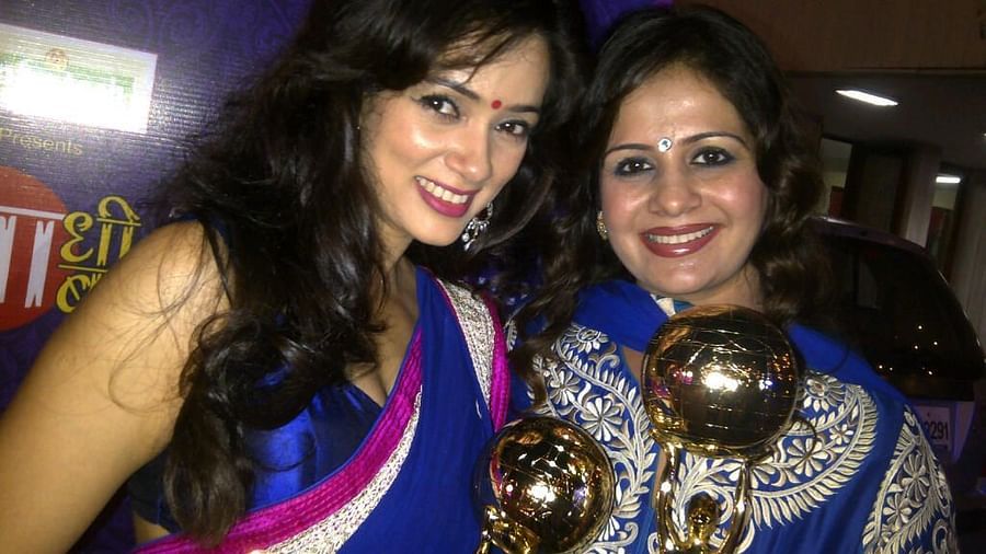 Kiran Bawa posing with an award and a celebrity - IOSIS Spa & Wellness