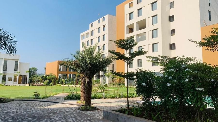 A dutch view of Pride Resort Ambaji's Facade with small plants around it