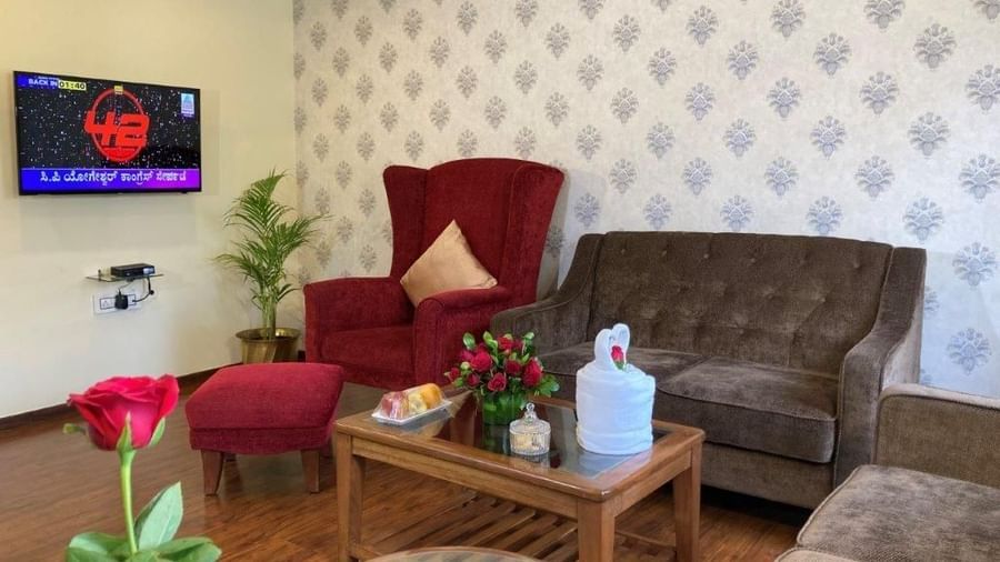 A small hotel lounge area with a red sofa, chairs, and a coffee table.