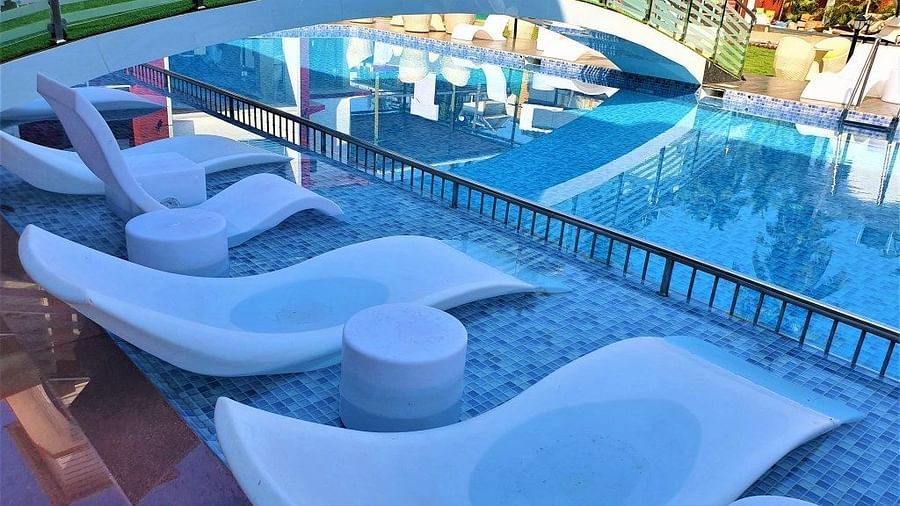 swimming pool with loungers on the side and a bridge to cross it - VITS shanti solitaire, North Goa