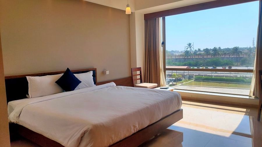 A picture of a king-size bed near a large window, with light streaming into the room.
