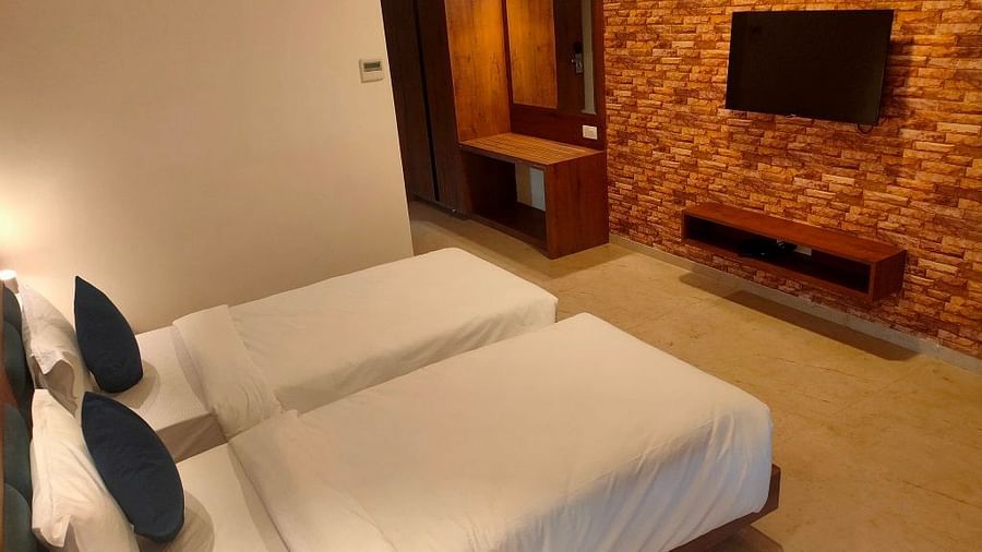 A picture of our hotel room featuring two twin beds, excellent lighting, and a TV for enjoyment