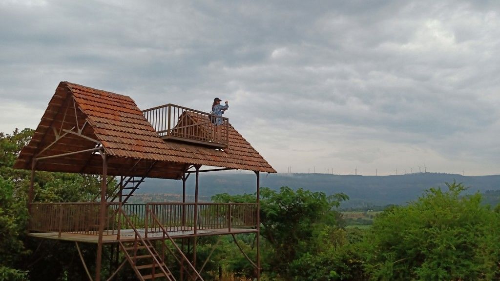 An elevated wooden structure at Forest Escapes Koyna offers panoramic views of the surrounding landscape.