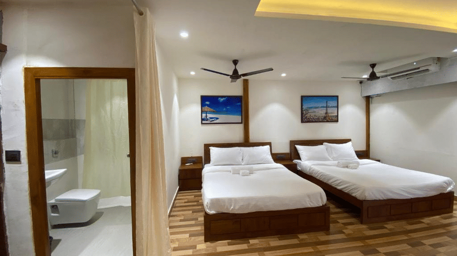 Well-appointed guest room with 3 double beds, wall-mounted landscape art, and an attached bathroom entrance - DAN Resorts & Weddings, Palghar