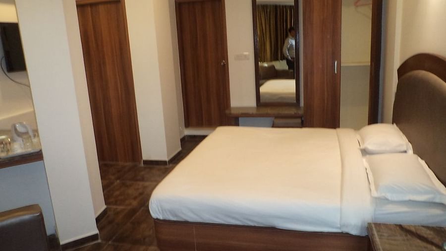 Room with double bed, wardrobe, and full-length mirror