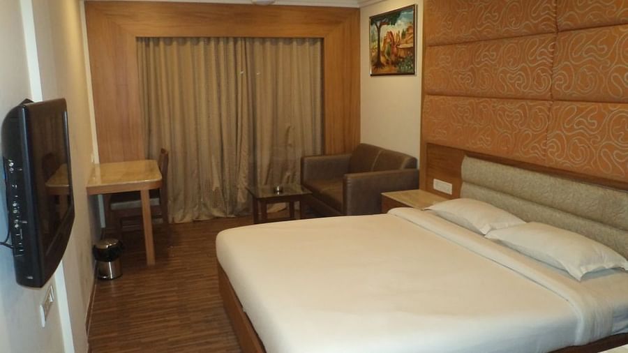 Hotel room with king-sized bed, flat screen TV, and work desk