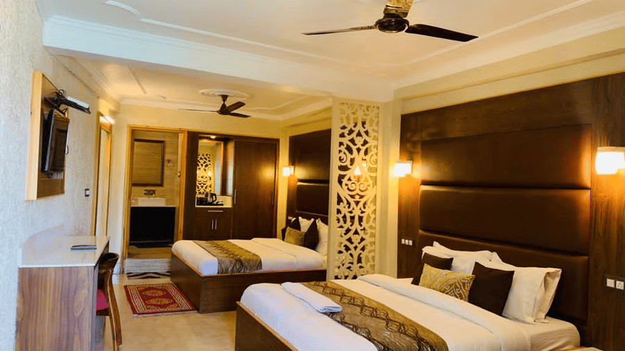 2 plush beds placed beside each other in a spacious and well-lit room at Mongas Hotel & Resort, Dalhousie.