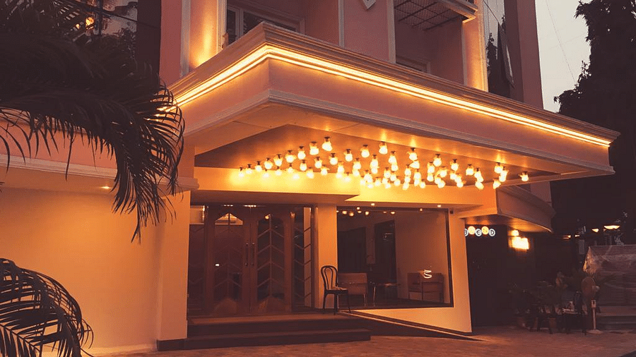 The image shows a brightly lit entrance to a hotel at night.