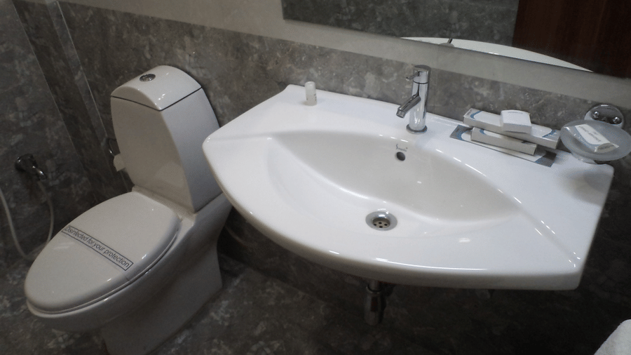 Modern bathroom with a toilet and sink with marble finish