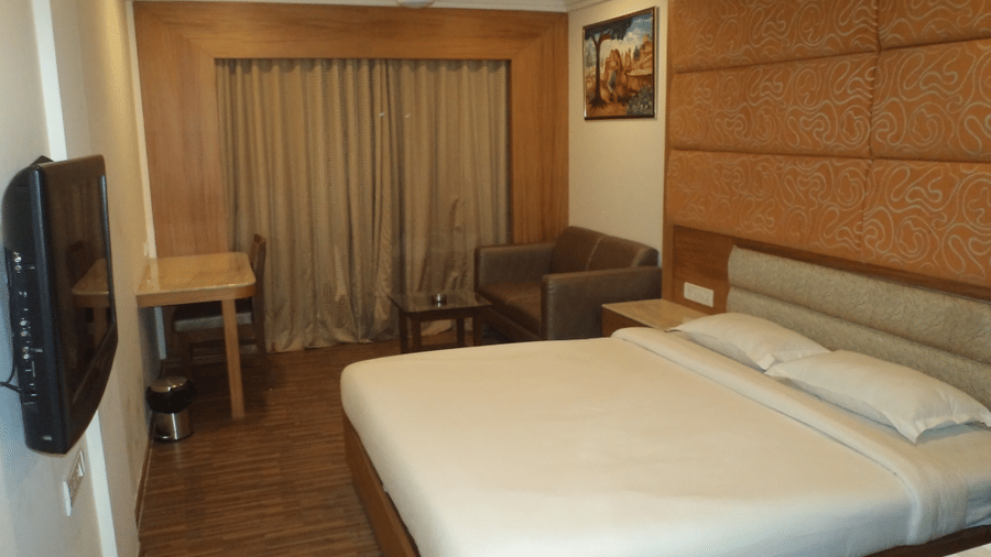 Hotel room with king-sized bed, flat screen TV, and work desk