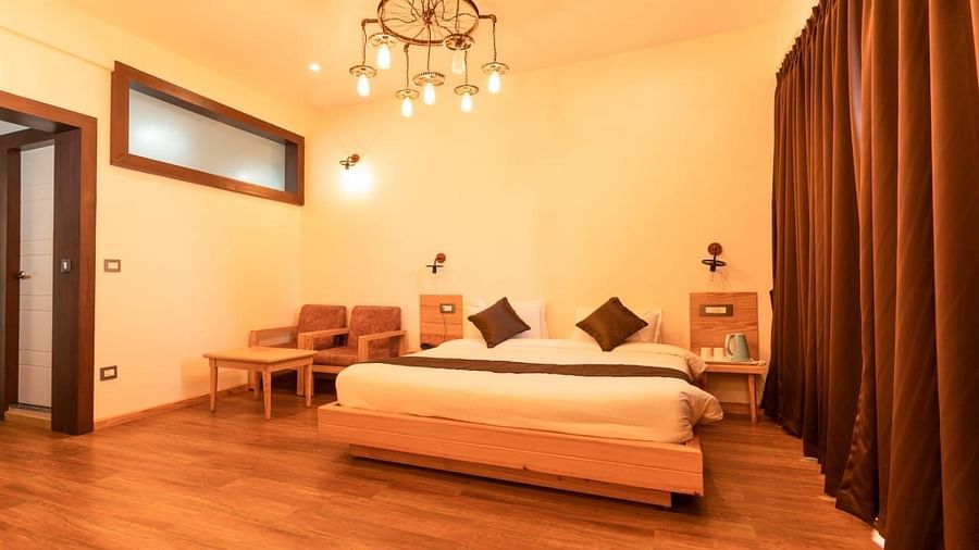 A bedroom with a bed, warm lighting, interior setting - Clarks Exotica Resort, Near Mukhteshwar.