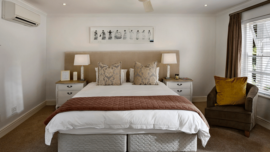 A double bed with a ceiling fan hanging over it in a bedroom.