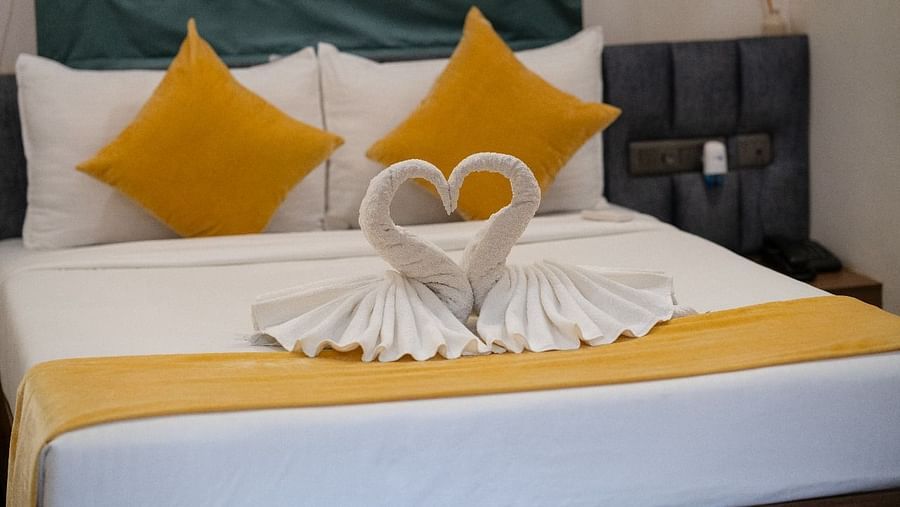 A neatly made bed with heart-shaped towels and pillows at Hotel Kyzen Smartstays – Smart, Reliable, Kyzen