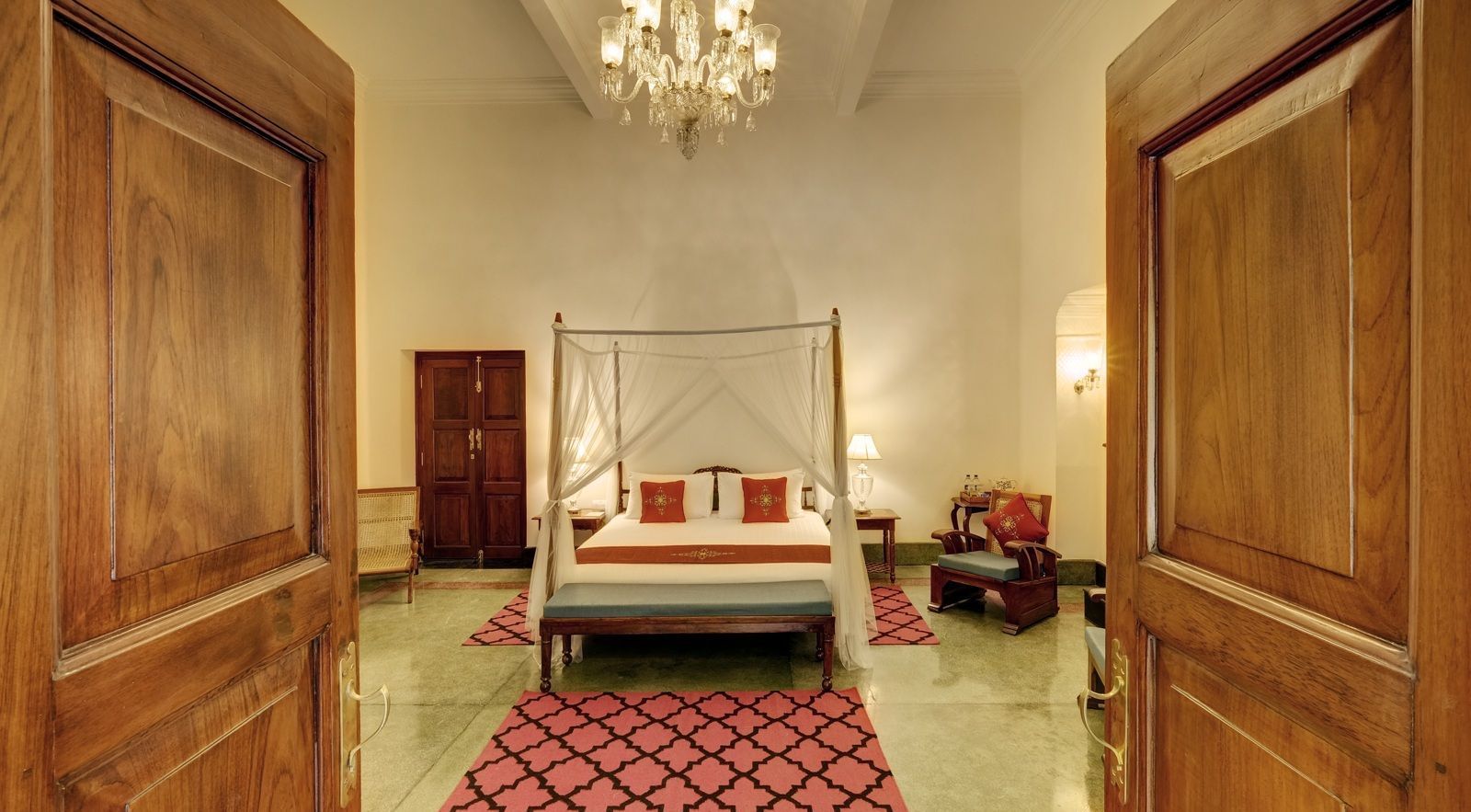 Saraca Suite at Saraca Hotel, Lucknow wit h a double bed and a chandelier hanging from the ceiling