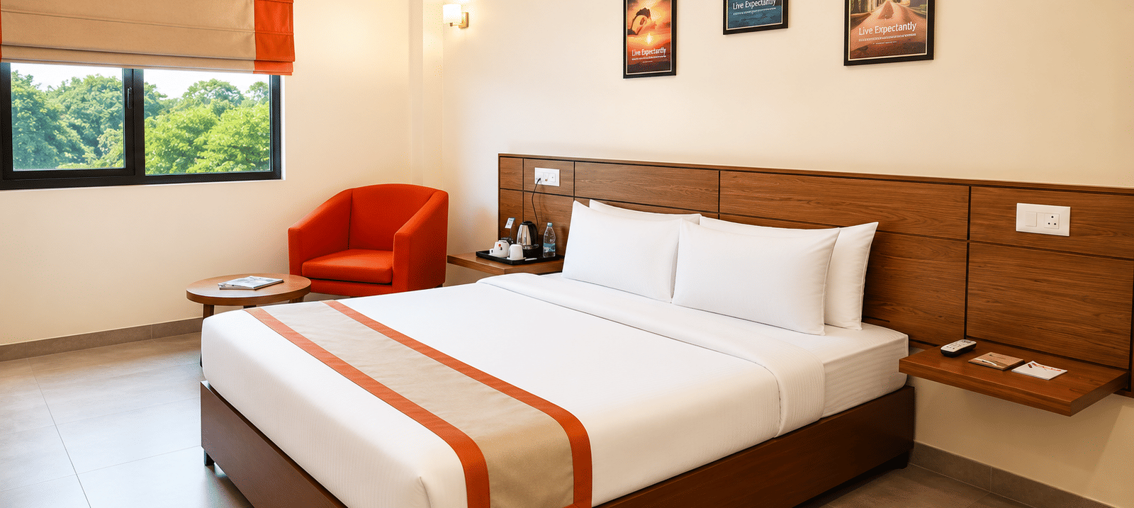 Max Queen Room at Max Hotel Jabalpur featuring a queen size bed, bedside tables and large windows with natural light.