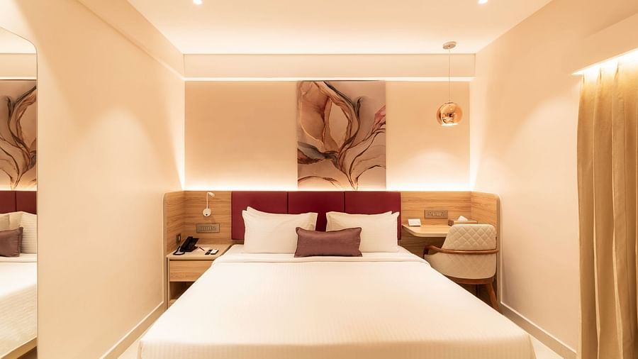 King-sized bed with wall art in The Executive Rooms at Livancia The Sojourn, Bangalore.
