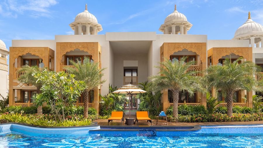 An image of our palace pool with sun loungers and palm trees on the deck - Kaldan Samudhra Palace