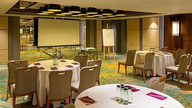 Senator Hall at The Residency Towers Puducherry, featuring round table seating arrangements and a presentation board.