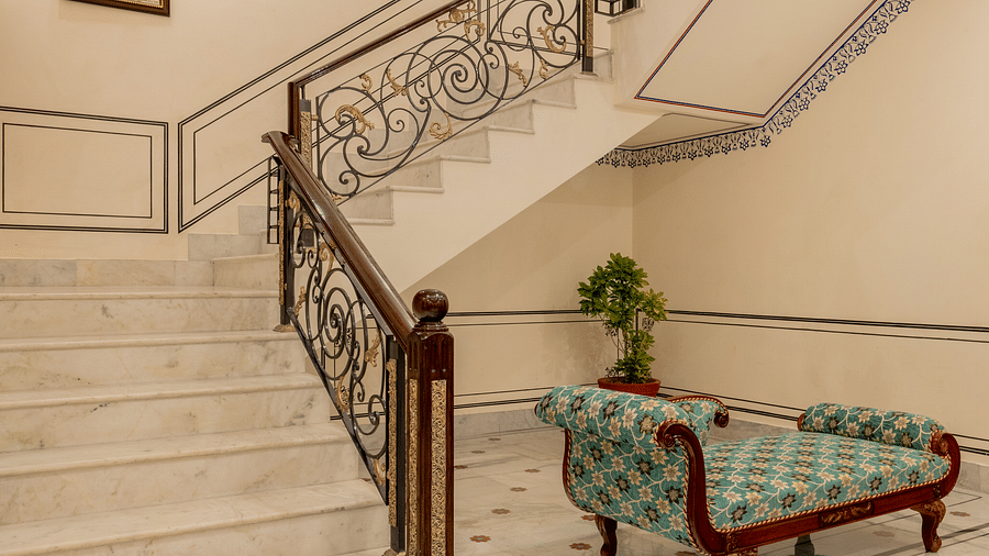 a staircase leading tot he first floor from the lobby area made with white marble stones - Brij Castle, Jaipur