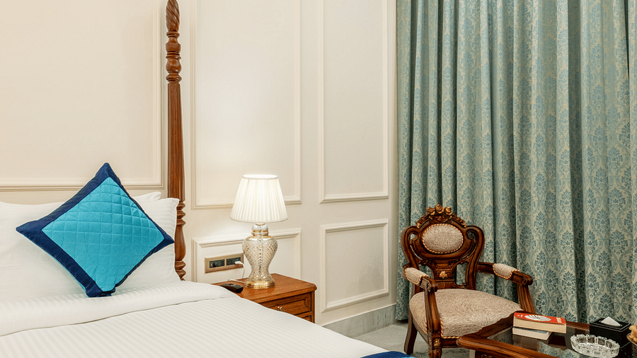close up image of the bed overlooking an arm chair along with a bed side table beside it - Brij Castle, Jaipur