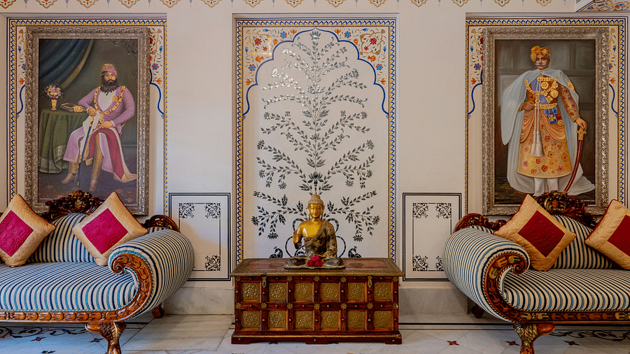 two plush couch with two cushions placed on each with two huge portraits of men from a royal family - Brij Castle, Jaipur