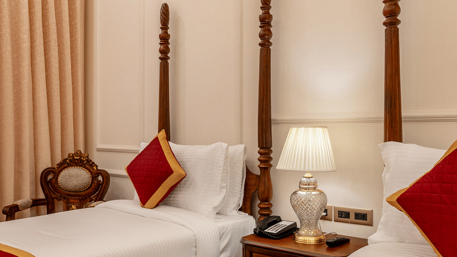corner view image of a twin bed with a bed side lamp in the middle of them - Brij Castle, Jaipur