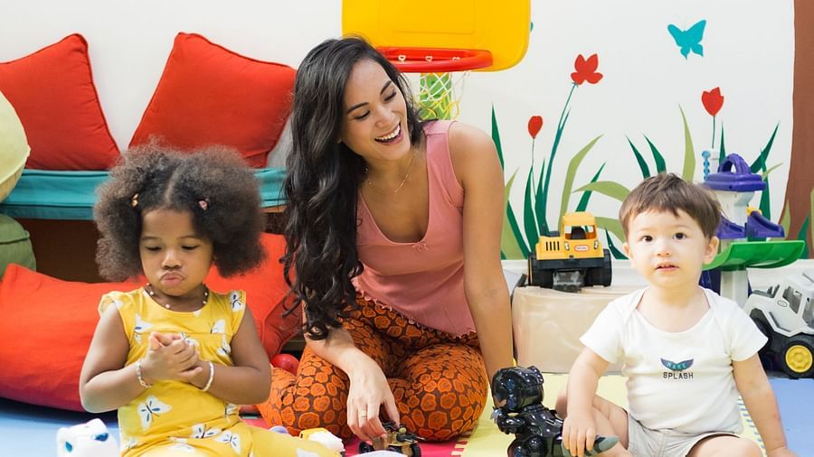 Two kids with a woman playing with toys in a kids room | Central Mansions, Phnom Penh