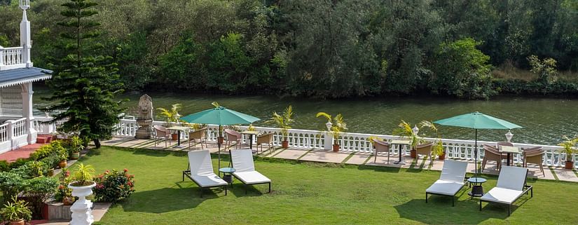 The Riverview outdoor seating arrangement amidst lush green scenery - Stone Wood Riverfront Resort, Siolim