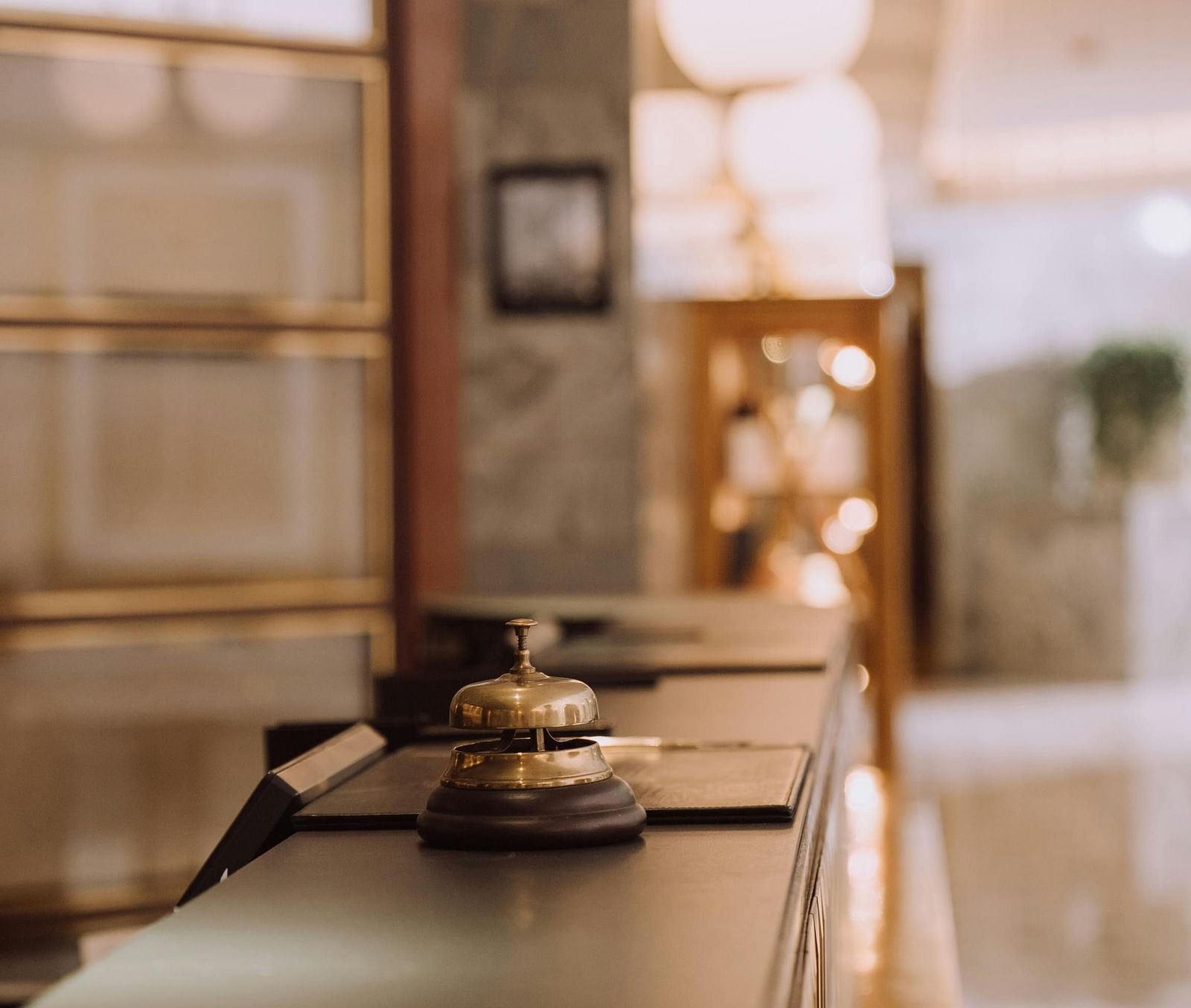 Close up shot of a concierge bell kept on a reception desk.