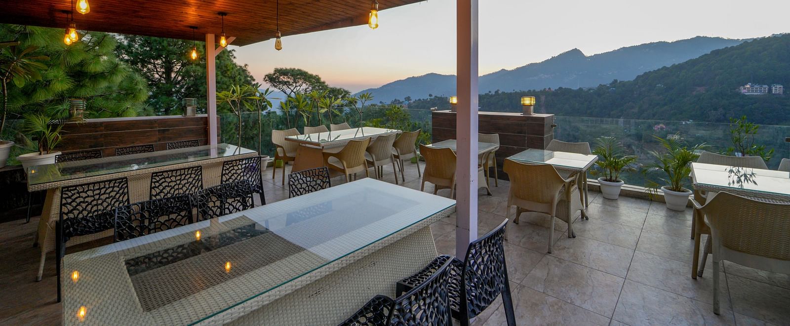 The terrace-top dining at DLS Whispering Winds with the set up of chairs and tables overlooking the view