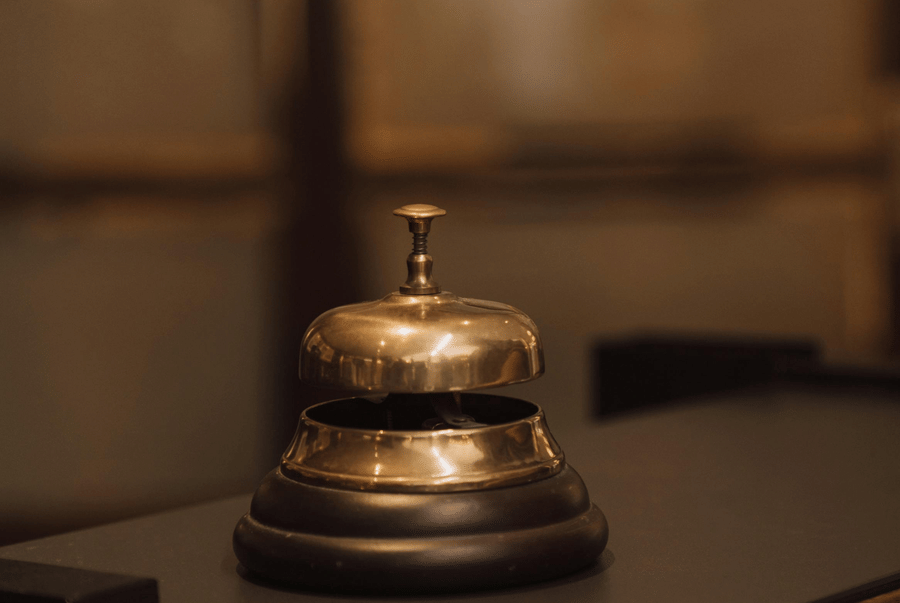 A metal service bell placed on a polished counter.