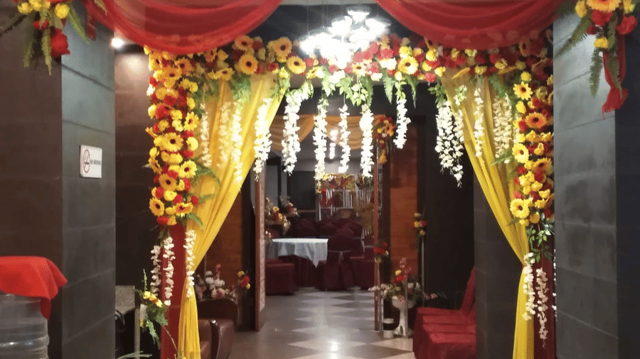 Elegant entrance décor with red drapes, yellow floral arrangements, and warm lighting at Central Courtyard Boutique Hotel.