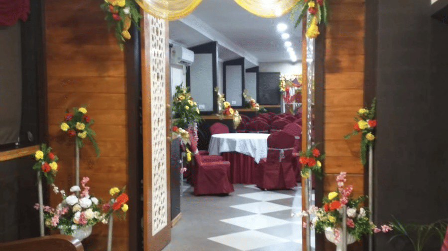 Stylish banquet entrance with golden drapes, floral accents, and a welcoming ambiance at Central Courtyard Boutique Hotel.