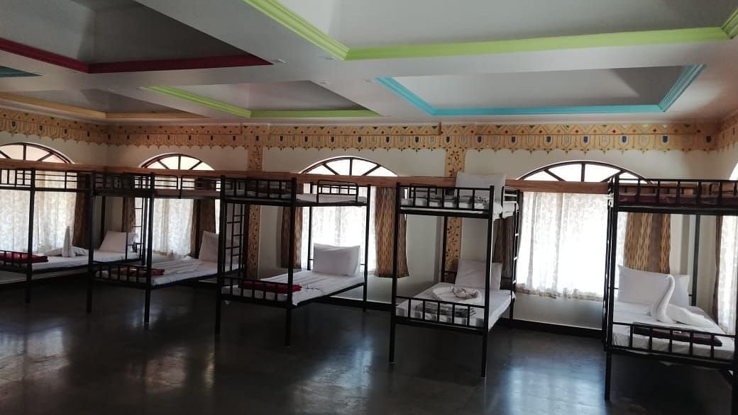 A room at Riverside Inn with bunk beds arranged side by side and windows behind them.