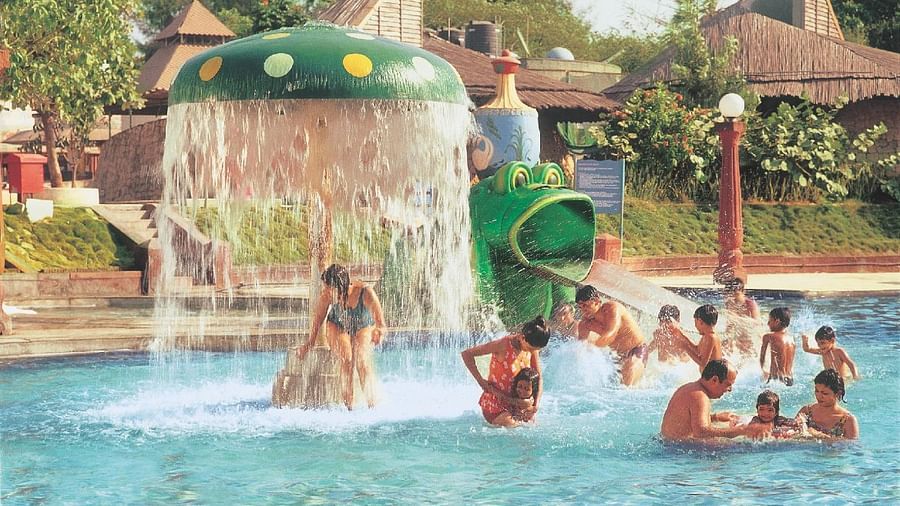 Water Kingdom - a group of people frolicking in a pool during daytime