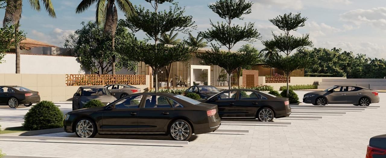 A parking lot with several cars parked, surrounded by palm trees and other greenery, under a bright sky.