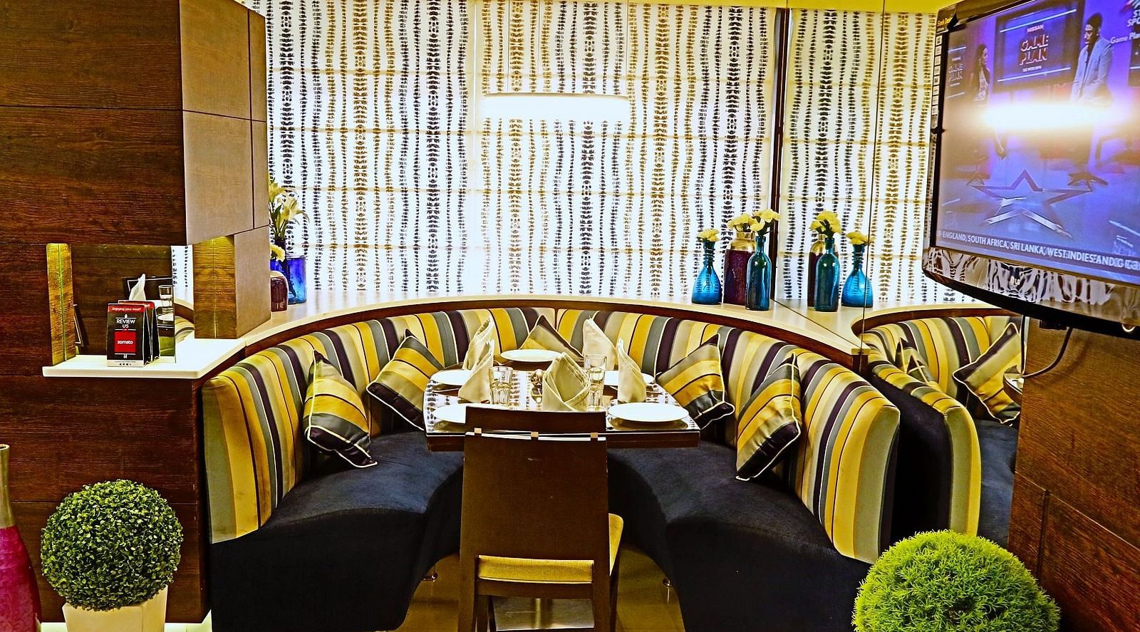 Image of a dining corner with sofas and plants on the side  at The Oriental Residency